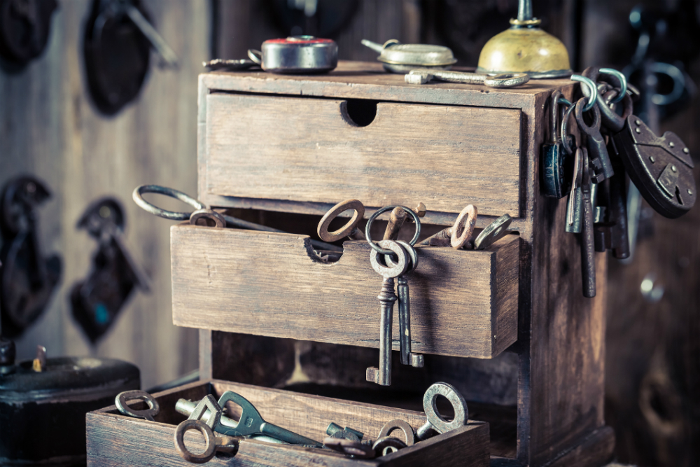 wooden drawer overflowing with old keys of varying sizes and designs